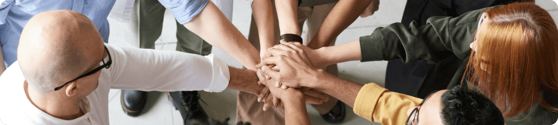 Team members joining hands in a circle